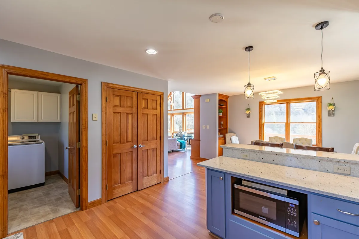 A wide view of the kitchen and dining area, where a kitchen island with bar seating transitions seamlessly into the adjacent dining space. Stainless steel appliances, granite countertops, and ample natural light create a warm, welcoming environment perfect for shared meals and socializing.